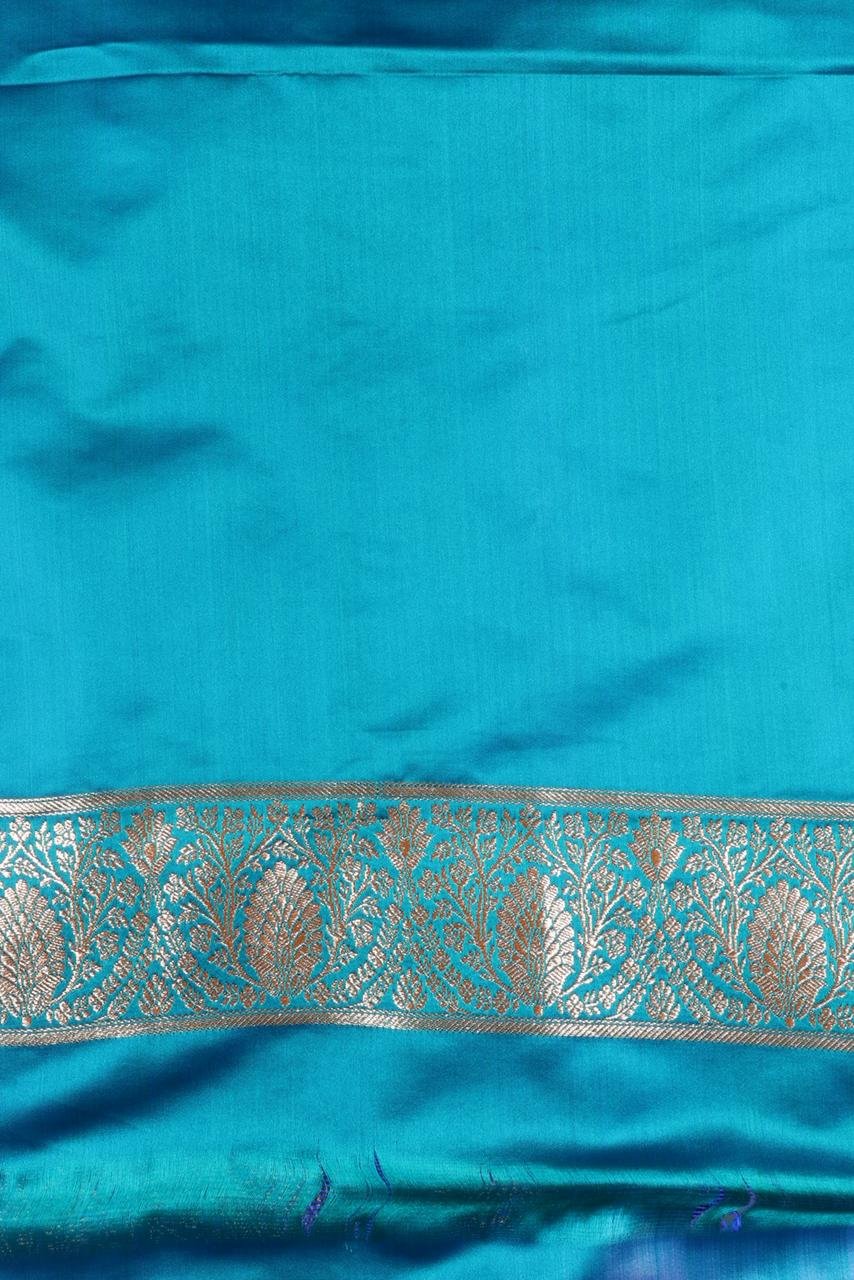 Blue Banarasi saree features intricate silver floral motifs woven throughout the body