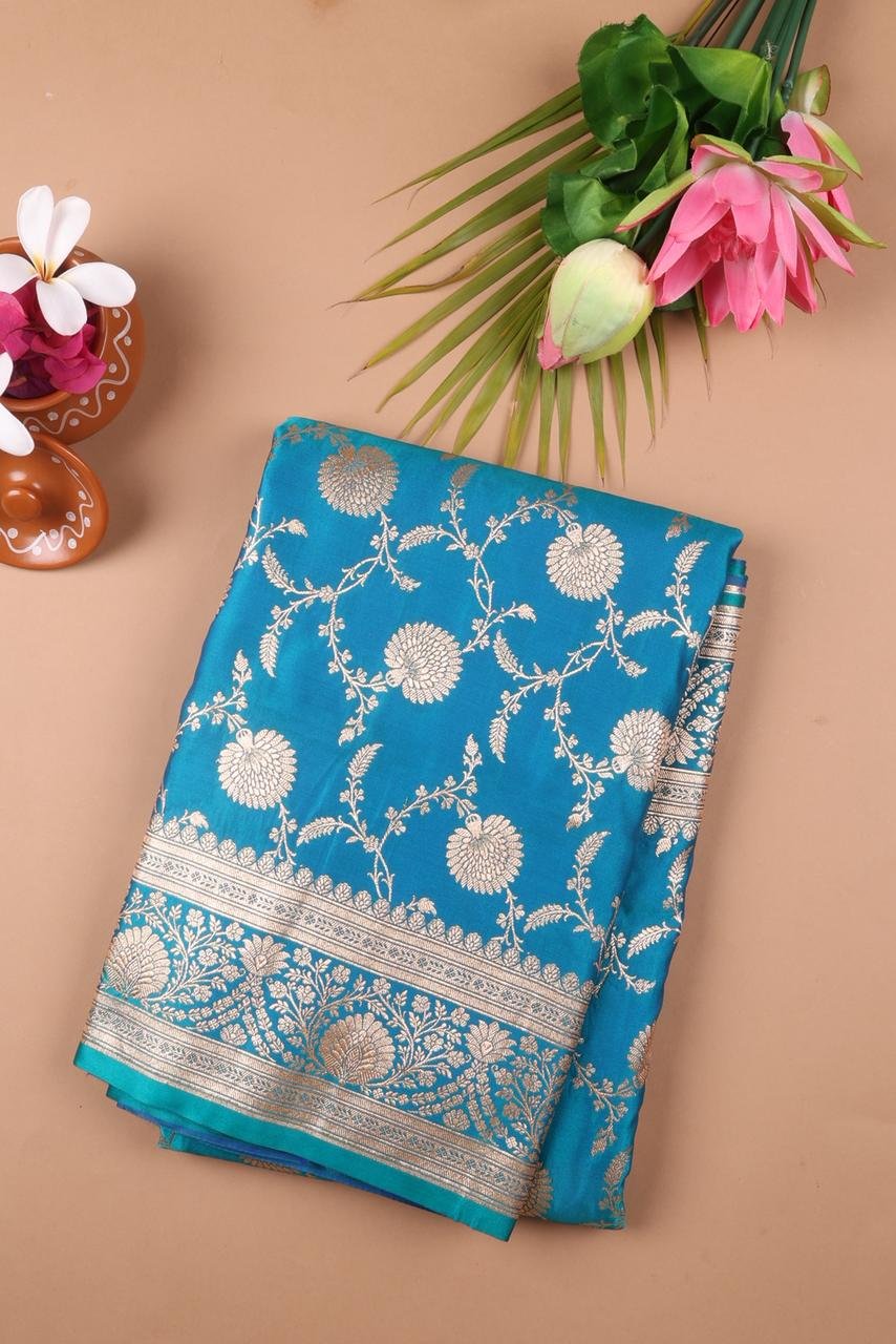 Blue Banarasi saree features intricate silver floral motifs woven throughout the body