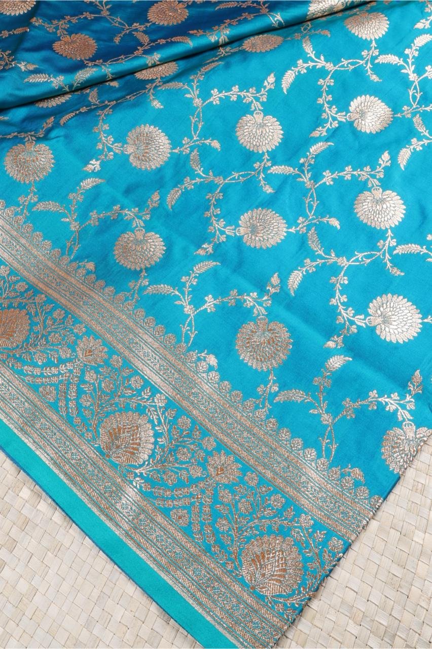 Blue Banarasi saree features intricate silver floral motifs woven throughout the body
