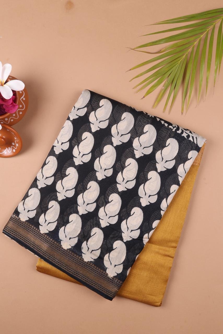 Maheshwari saree features a bold black body adorned with cream-colored floral motifs perfectly contrasted by a vibrant mustard-gold pallu