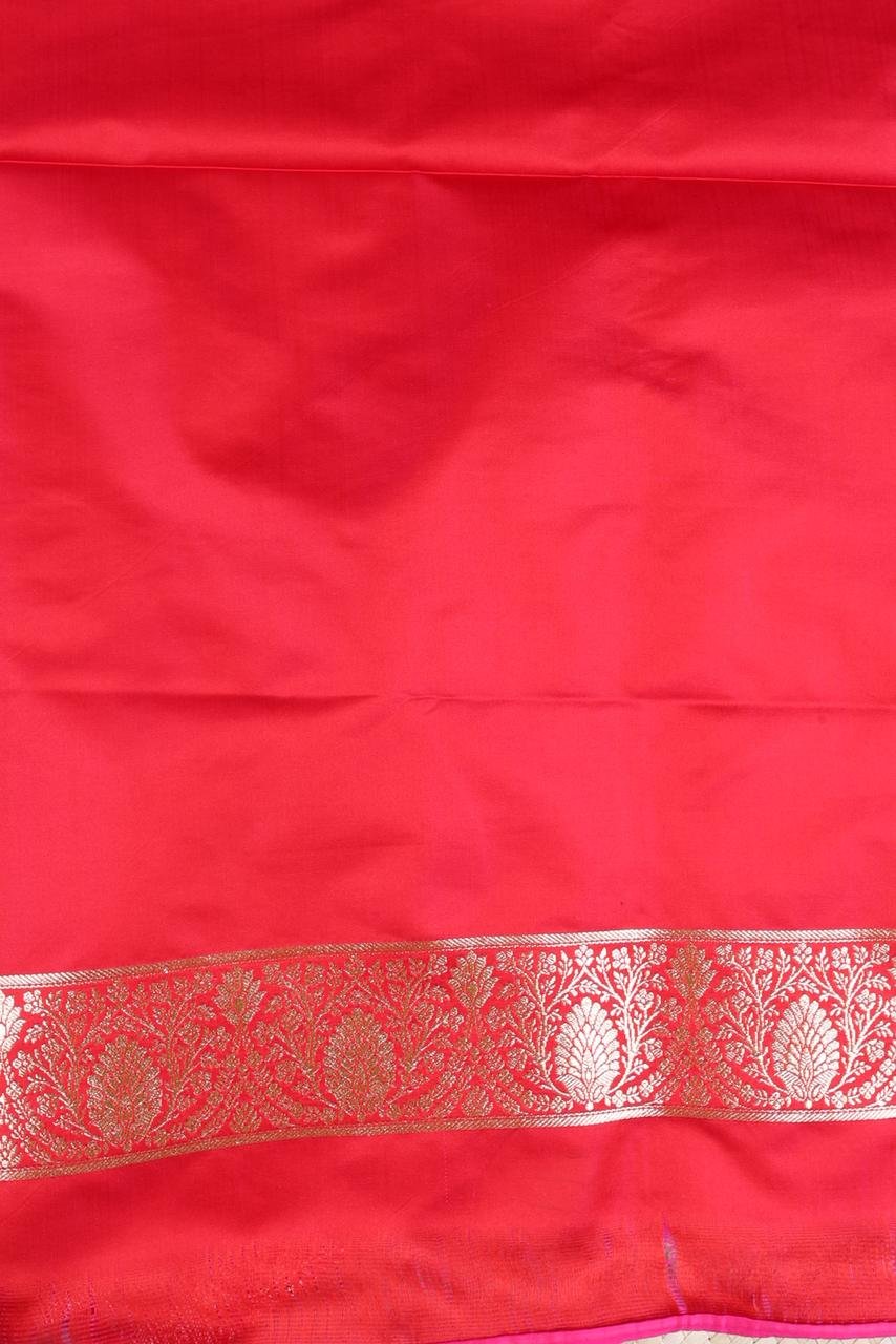 Red Banarasi saree features intricate silver floral motifs woven throughout the body