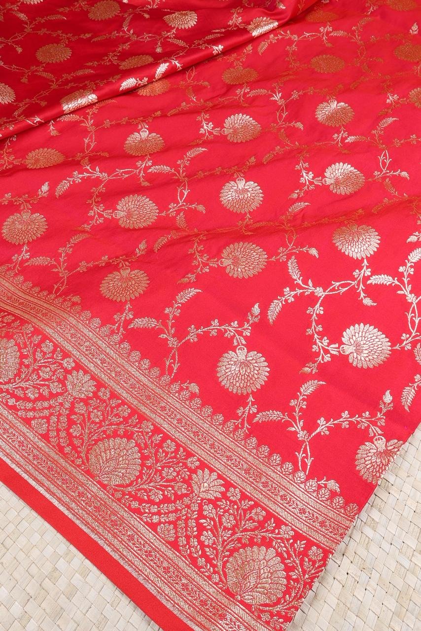 Red Banarasi saree features intricate silver floral motifs woven throughout the body