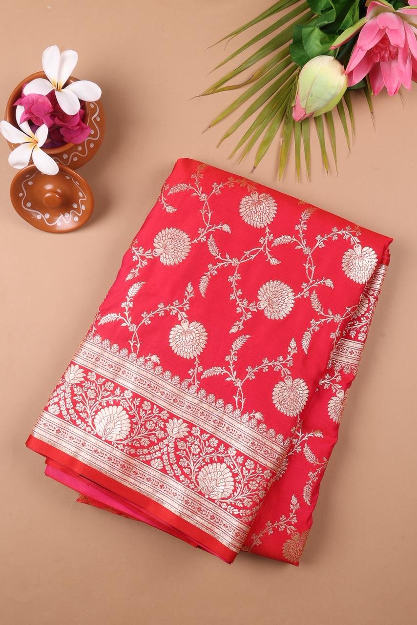 Red Banarasi saree features intricate silver floral motifs woven throughout the body